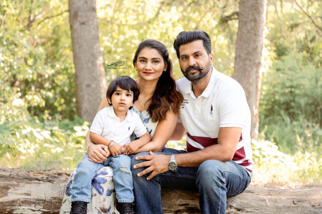 family of 3 sitting on a log during their Family Photography Session in Edmonton