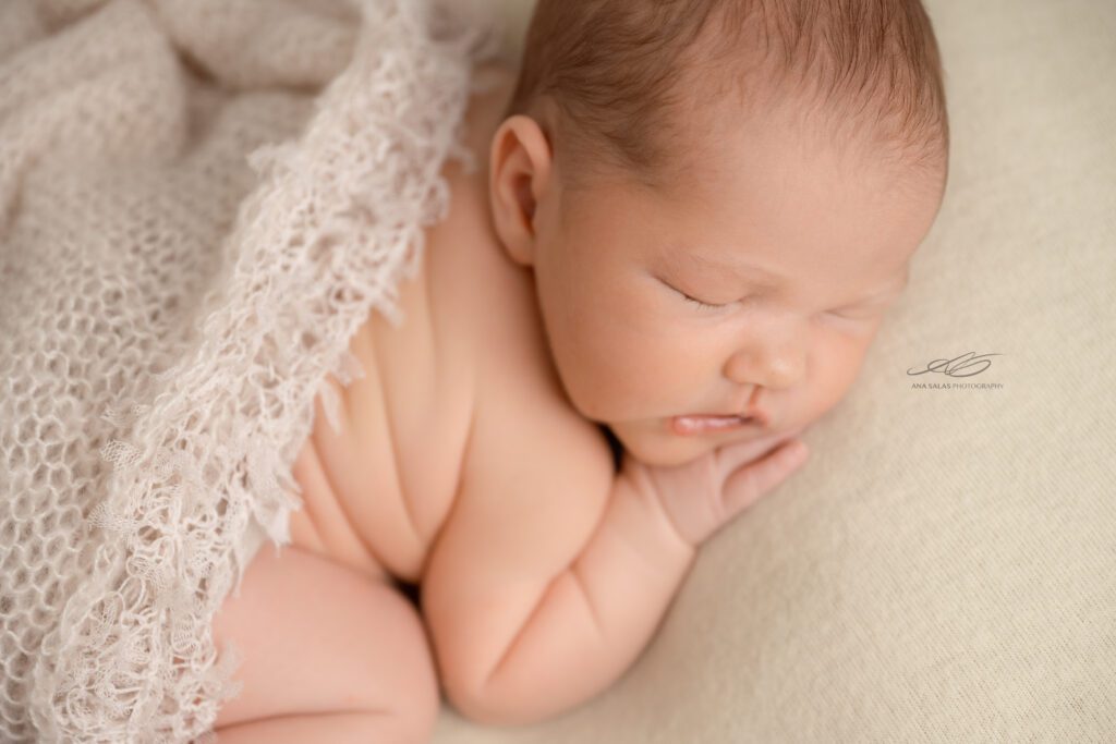 newborn baby with a cheesecloth draped over them sleeping during their Newborn Photo Session in Edmonton