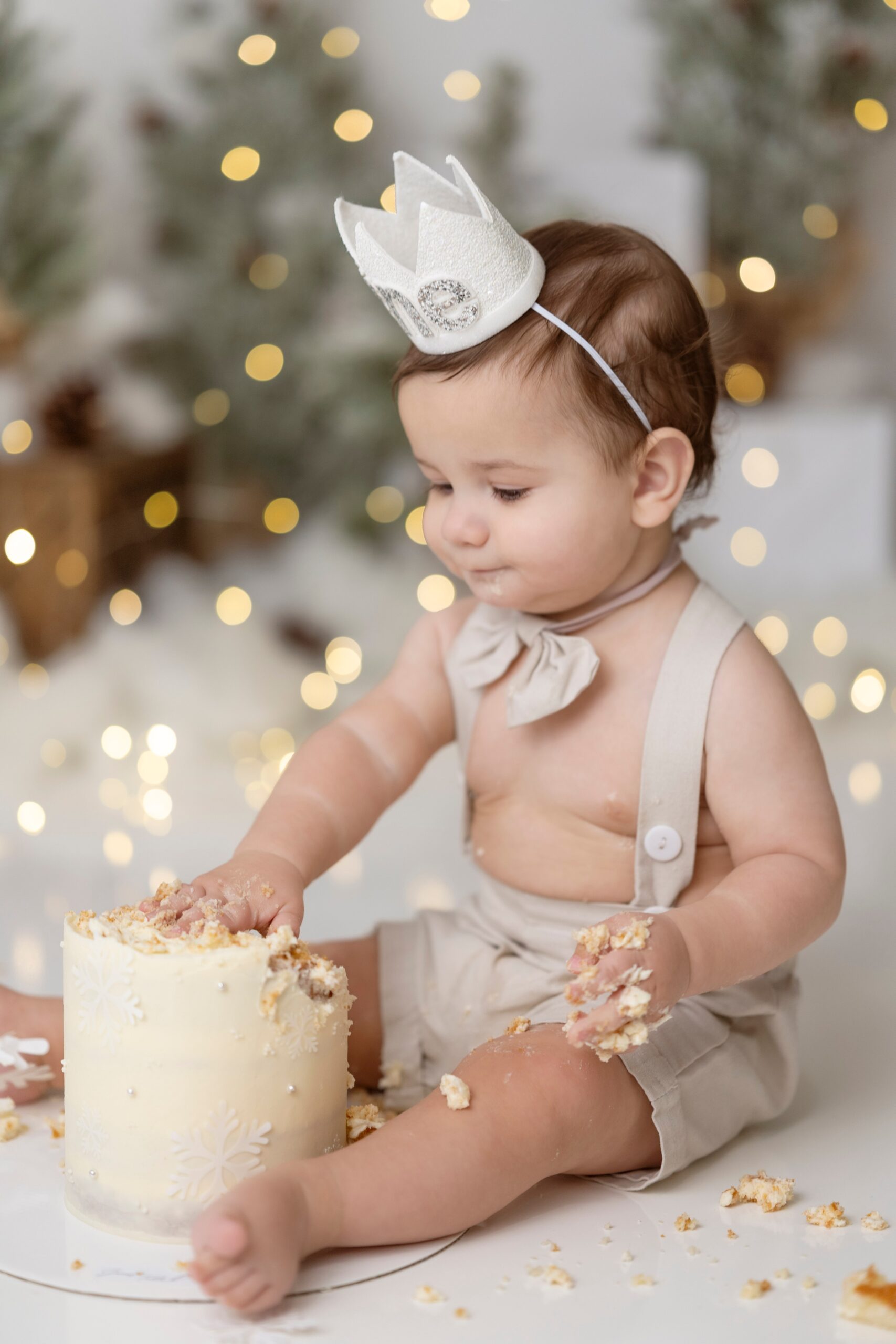 A happy young toddler smashes a cake in a christmas themed studio before visiting edmonton preschools