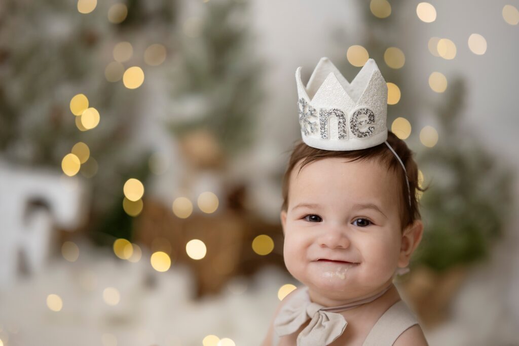 A young toddler sits in a studio covered in cake in a birthday crown before visiting edmonton preschools